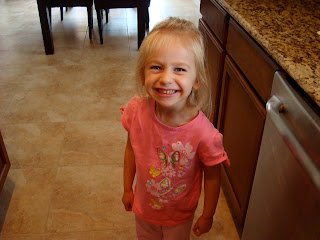 Little girl standing in kitchen smiling wearing pink t-shirt - 25