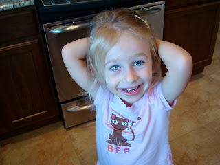 Young girl in kitchen with hands behind head