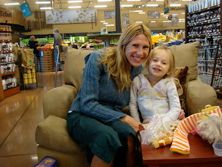 Young girl and woman sitting together on oversized chair