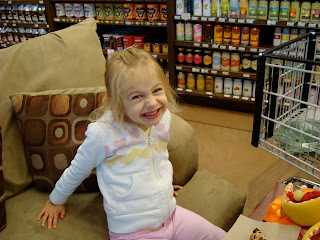 Young girl giving large smile while sitting on oversized chair