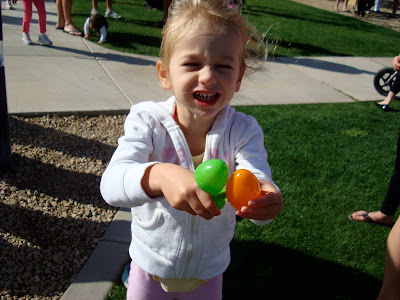 Young girl holding green and orange Easter eggs