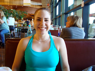 Woman in blue tank smiling sitting in booth