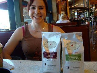 Woman sitting in booth with two packages of coffee in front of her