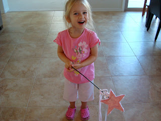 Young girl in pink holding princess wand