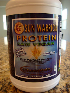 Container of un Warrior Brown Rice Protein Powder in Chocolate