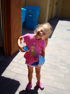 Young girl with head cocked to side with glove and ball