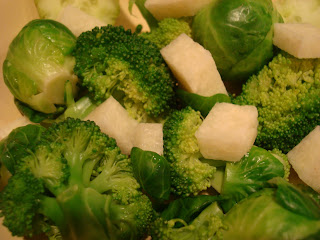 Broccoli with greens, jicama and Brussel sprouts in bowl