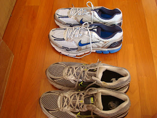 Two pairs of running shoes next to one another one old one new