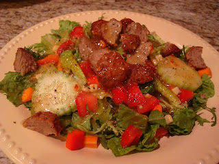 Salad in shallow bowl with chopped up meatballs