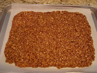 Granola spread on out parchment paper lined baking sheet