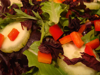 Greens with cucumbers and diced red peppers