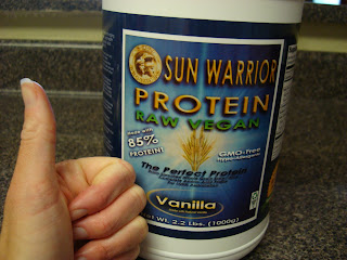 Sun Warrior Vegan Vanilla Protein Powder in container and hand holding thumbs up