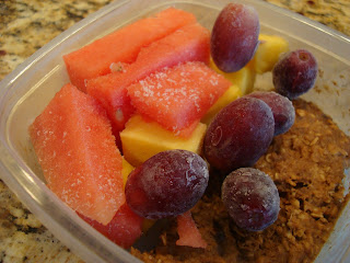 Clear container with breakfast cookie, grapes, watermelon and pineapple