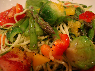 Close up of Spiralized zucchini noodles topped with mixed vegetables and dressing