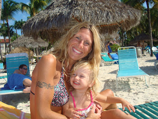 Woman and young girl on beach chair in swimsuits smiling