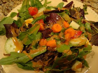 Mixed green salad with vegetables on white plate