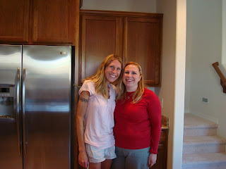 Two women standing in kitchen smiling