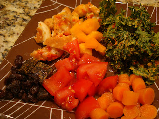 Dinner plate filled with chipped cheese pizza, kale chips and vegetables