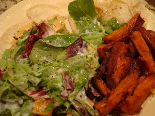 Salad and sweet potato fries served on white plate