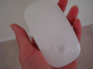 Hand holding Apple Mouse at angle