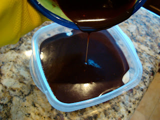 Hand pouring chocolate mixture over powdered sugar layer