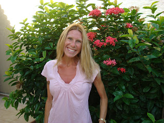 Woman smiling in front of flowering shrub