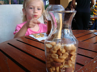 Close up of mixed nuts in jar with young girl in background
