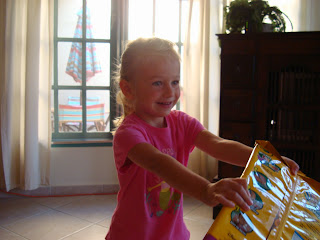 Young girl holding up one unwrapped present