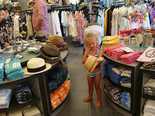 Gift shop with young girl playing with hat