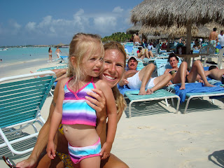 Woman and young girl in bathing suits on beach smiling