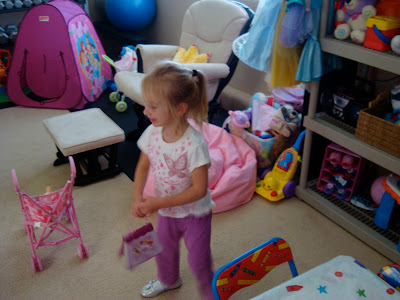 Young girl playing in toy room by dress up clothes