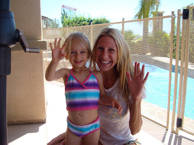 Woman and child in front of pool waving