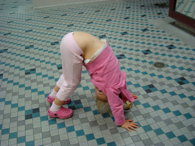 Young girl doing yoga pose on floor