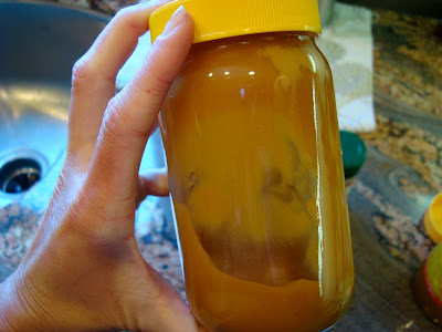 Hand shaking lidded jar of Peanut Sauce