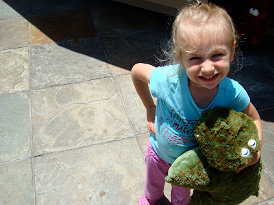 Young girl holding green stuffed animal - 21