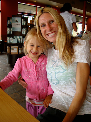 Woman and young girl hugging and smiling at table
