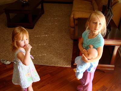 Two young girls one holding baby doll