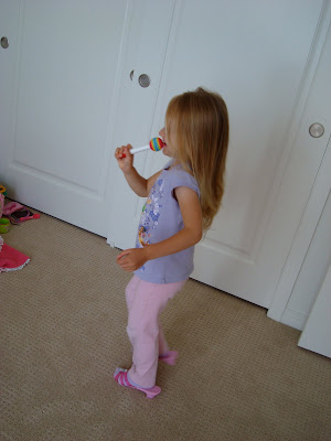 Young girl dancing and singing into toy like microphone