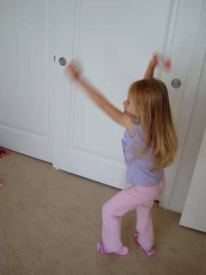 Young girl running around room dancing with arms up in air