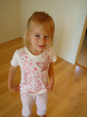 Young girl in butterfly t-shirt standing looking at camera 