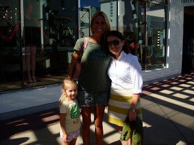 Two women and young girl standing in front of store front