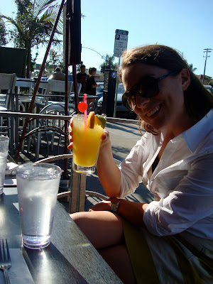 Woman sitting at table holding up drink