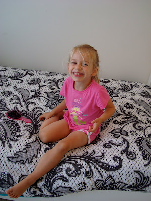Young girl sitting on new bedding