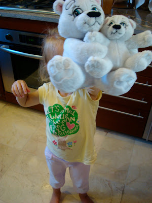 Little girl holding two stuffed bears