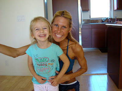 Woman in workout clothes with arm on child smiling