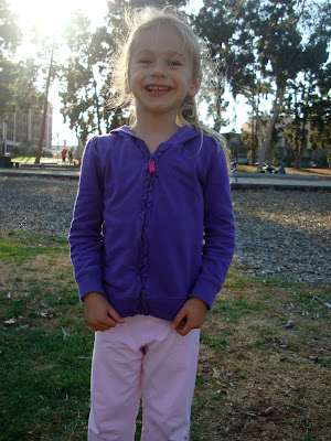 Young girl standing at park smiling