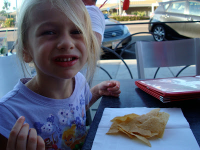 Young girl at table with pile of chips in front of her
