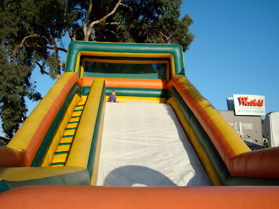 Young girl at top of giant blow up slide