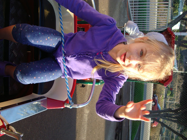 Young girl on train pulling hand down like train conductor