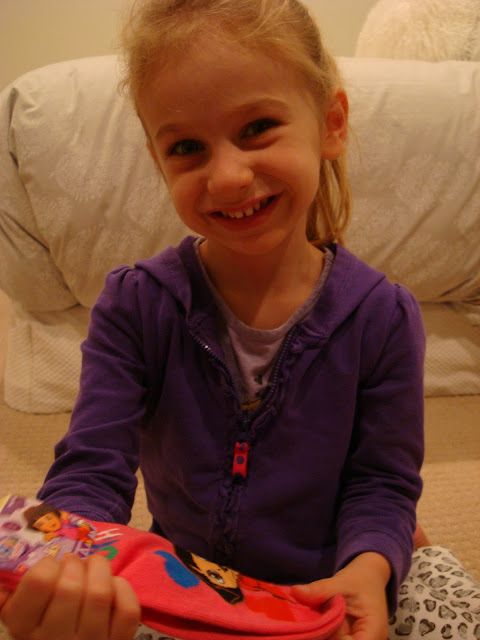 Young girl holding Dora socks smiling
